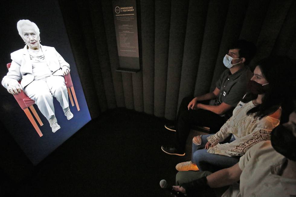 July 29, 2021 - Los Angeles, California, United States: Students Jacob Manela, Sophia Kangavari and Will Spangler, left to right, interact with 97-year-old Holocaust survivor Renee Firestone -- one of the oldest remaining such survivors in the world appearing in "Dimensions in Testimony," which gives visitors the opportunity to have a virtual "one-on-one" conversation with Renee as a Holocaust survivor. The pioneering project integrates advanced filming techniques, specialized display technologies and next-generation natural language processing to create an interactive biography so the viewer can receive real-time responses to questions from pre-recorded video images. "Our museum was founded by survivors who wanted to share their stories publicly and educate the next generation," said Beth Kean, CEO of the Museum. "With 'Dimensions in Testimony,' countless future generations of visitors and students can hear those stories from the survivors and learn directly from those who were there, even when they are no longer with us."