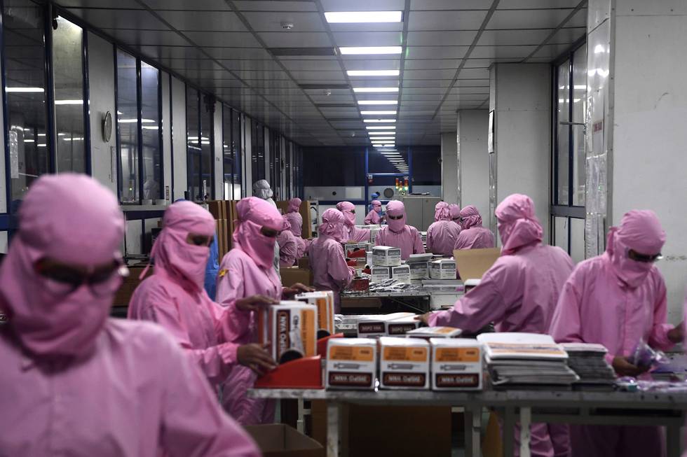 In this photograph taken on September 2, 2020, workers pack syringes at the Hindustan Syringes factory in Faridabad. - India's biggest syringe manufacturer is ramping up its production to churn out a billion units, anticipating a surge in demand as the global race to find a COVID-19 coronavirus vaccine heats up. (Photo by SAJJAD HUSSAIN / AFP)