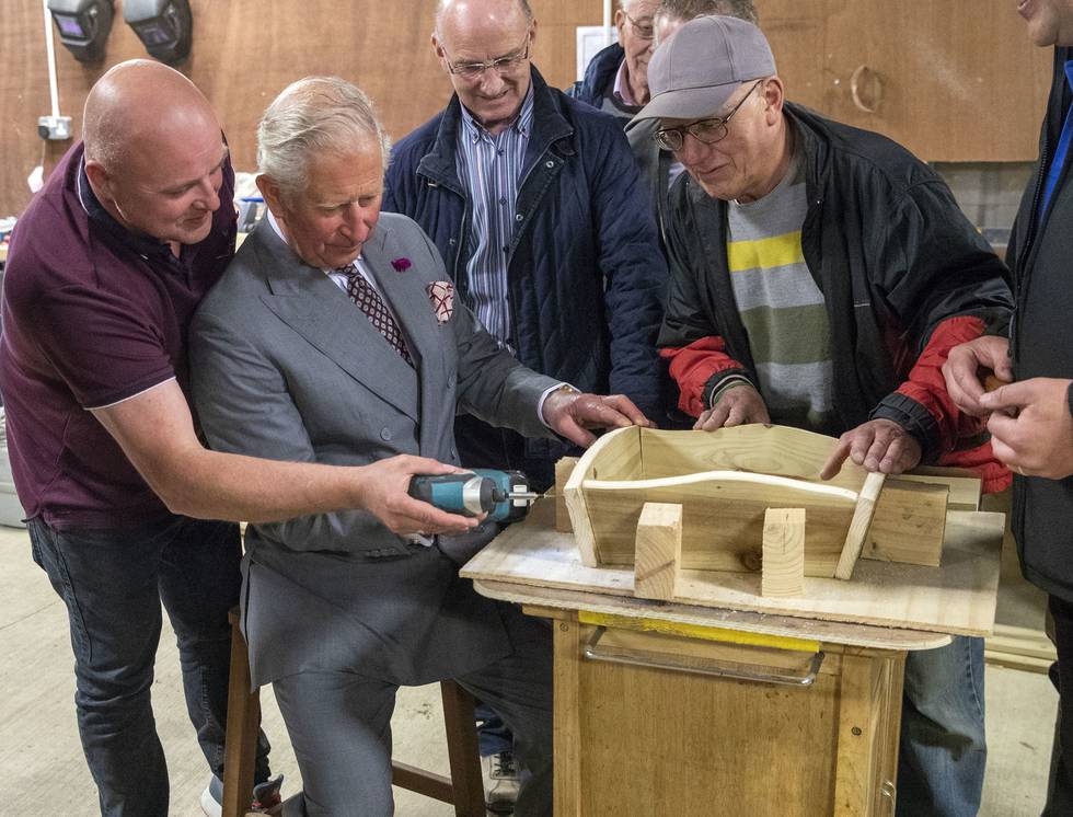 GORTIN, NORTHERN IRELAND - JUNE 13:  Prince Charles, Prince of Wales uses a power driver to put screws into an ornamental wheelbarrow during a visit to the Owenkillew Community Centre in Gortin, as part of his tour of Northern Ireland with the Duchess of Cornwall on June 13, 2018 in Gortin, United Kingdom. The Prince of Wales and Duchess of Cornwall are paying a four day visit to Northern Ireland and the Republic of Ireland.  (Photo by Steve Parsons - Pool/Getty Images)
