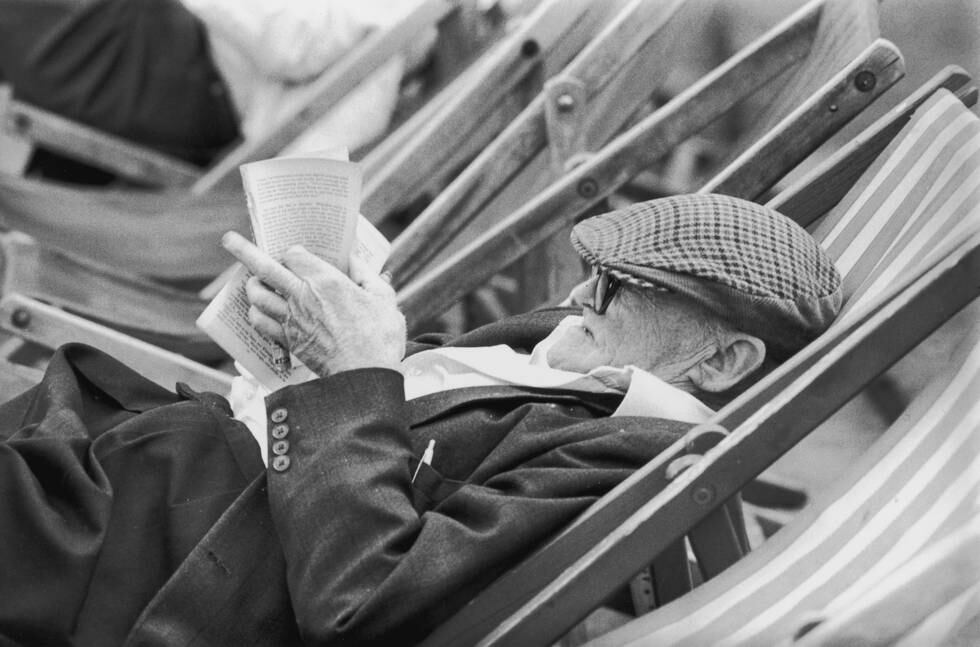 25th July 1980:  Slumped in a deckchair, an elderly man, his cap pulled down to rest on his glasses, reads a pamphlet.  (Photo by Evening Standard/Getty Images)