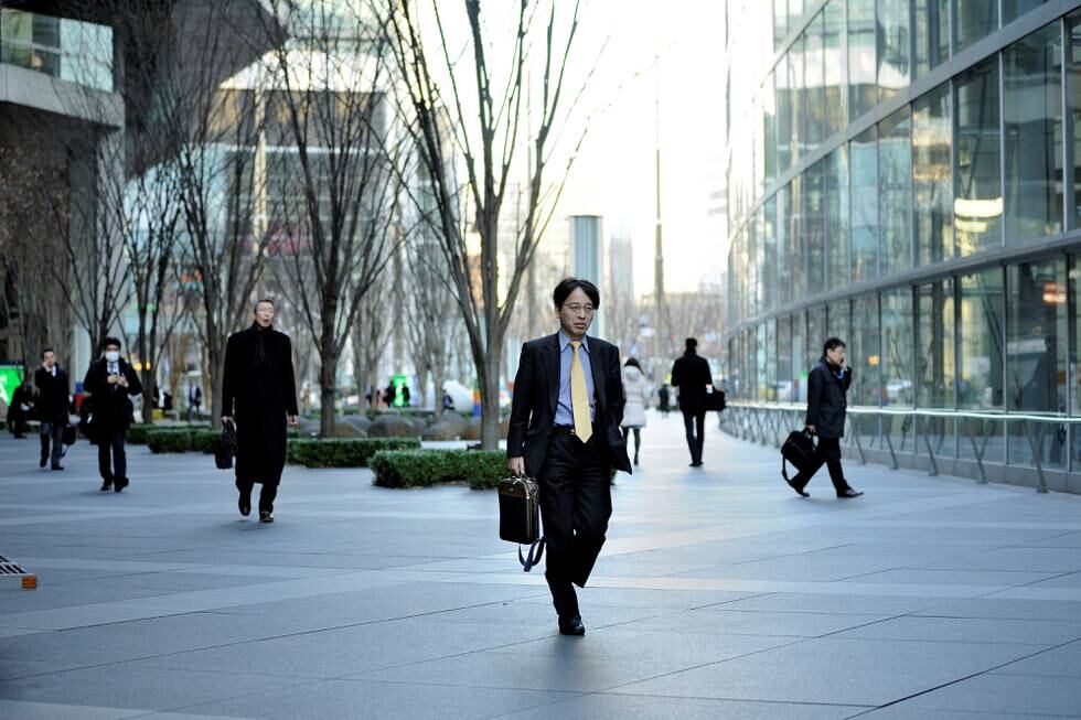 TOKYO, JAPAN - FEBRUARY 10: People walk at the Tokyo International forum in middle of the buildings of the financial and business district of Tokyo, Japan, on February 10, 2015. Japanese Prime Minister Shinzo Abe want to revitalise the economy and plans to reform Japan's labor laws.
