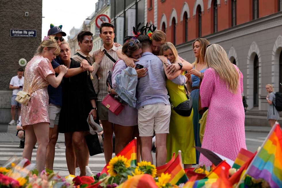 People comfort each other as they stand at the scene of a shooting in central Oslo, Norway, Saturday, June 25, 2022. A gunman who opened fire in Oslo’s nightlife district has killed two men and left more than 20 other people injured during the LGBTQ Pride festival in Norway's capital. (AP Photo/Sergei Grits)
