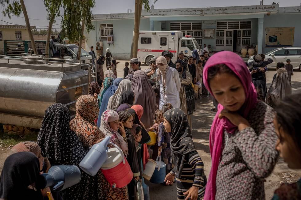 FILE — People line up for water at an encampment for internally displaced families, who have fled fighting in Kandahar and neighboring districts, at a compound in Kandahar, Afghanistan on Aug 3, 2021. Three major cities in western and southern Afghanistan were confirmed on Friday, Aug. 13, 2021, to have fallen to the Taliban, as the insurgents’ race to take control of the country accelerated. (Jim Huylebroek/The New York Times)